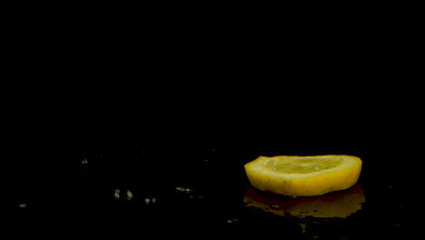 Zitronenscheibe,-Die-Sich-Dreht-Und-Auf-Eine-Schwarz-Verspiegelte-Oberfläche-Fällt