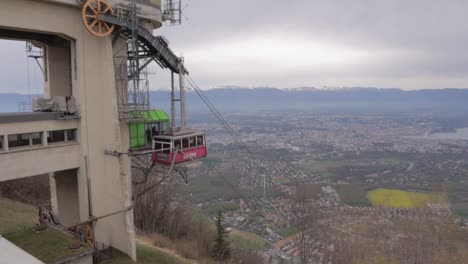 Salève-cable-car-slowly-leaving-the-top-station-from-the-mountain-with-Geneva-valley-in-the-background