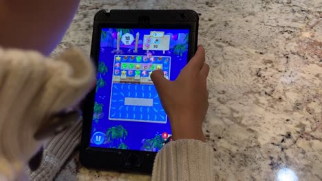 Little-boy-playing-a-popular-puzzle-game-on-the-iPad-called-"Angry-Birds-Match"