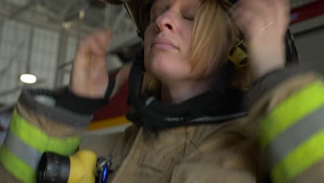 Female-firefighter-puts-on-protective-firefighting-helmet-and-gear-as-she-prepares-to-respond-to-an-emergency