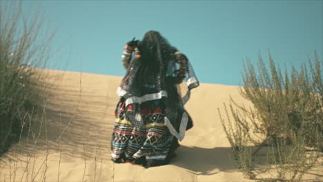 Mujer-Gitana-Escalando-En-Una-Duna-De-Arena-Del-Desierto