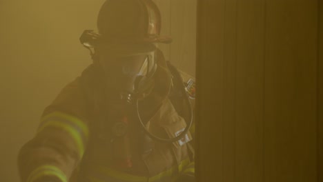Feuerwehrmann-Arbeitet-In-Einem-Verrauchten-Gebäude,-Während-Er-Ein-Feuer-Bekämpft