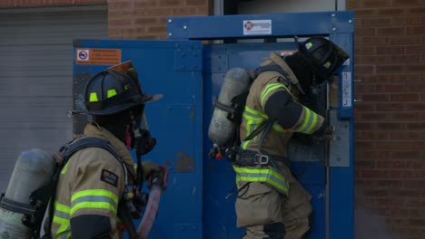 Firefighter-breaks-open-a-metal-door-at-a-burning-building-to-go-fight-a-fire