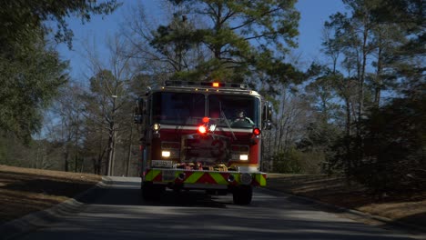 Firetruck-driving-on-a-residential-street-with-emergency-lights-flashing-to-respond-to-a-fire
