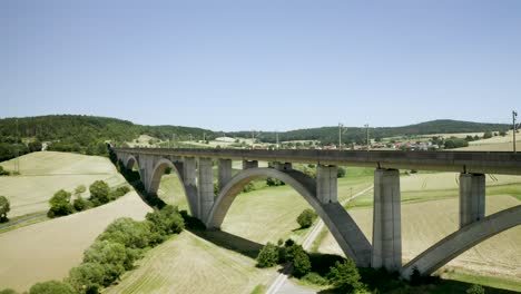 A-beautiful-viaduct-leading-a-train-over-the-German-Motorway-Autobahn-Highway,-Europe
