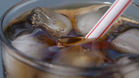 Macro-close-up-of-a-plastic-straw-being-placed-into-an-ice-cold-drink