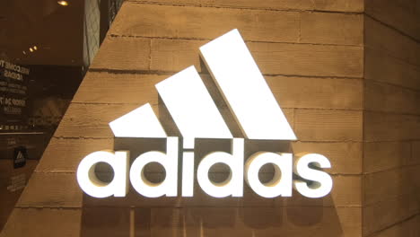 Adidas-brand-logo,-sports-front-store-in-shopping-center,-smooth-zoom-in,-editorial