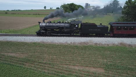 Aerial-View-of-a-Vintage-Steam-Engine-with-Passenger-Cars-Puffing-along-Amish-Countryside