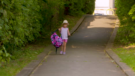 Cute-little-girl-taking-her-backpack-off-as-she-walks-home-from-school