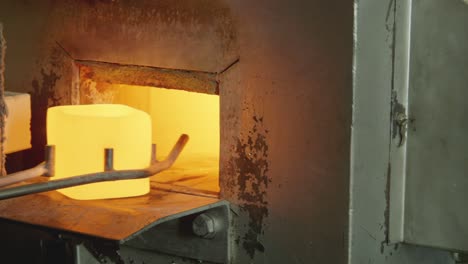 Taking-a-crucible-out-of-a-oven-and-pouring-liquid-metal-into-another-crucible