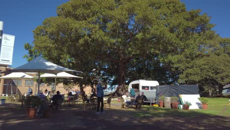 Elderlies-and-tourists-are-enjoying-coffee-from-a-mobile-cafe-and-breathing-fresh-air-in-the-middle-of-a-park,-Sydney,-Australia