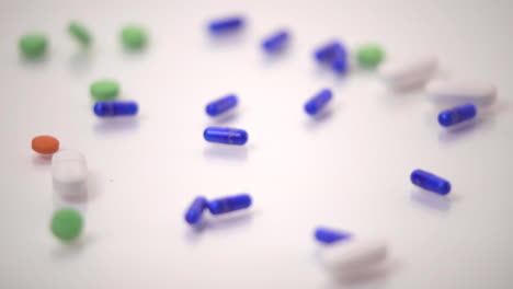 Slow-Motion-Macro-of-Pill-Varieties-Dropped-onto-White-Background