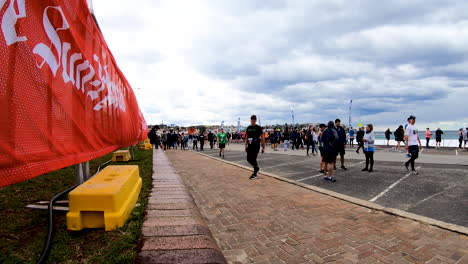Runners-moving-along-Bondi-Beach-promenade-after-completing-the-CIty2Surf-2019-fundraiser-race-sponsored-by-Westpac-hyperlpase