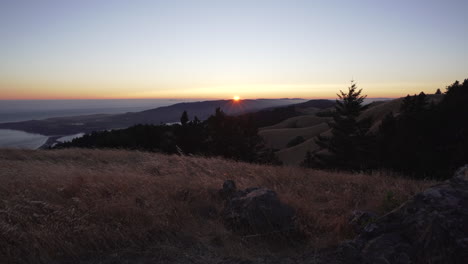 Sun-setting-just-above-the-horizon-on-Mount-Tamalpais-with-Stinson-beach-and-rolling-hills-in-the-background