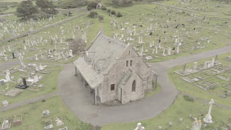 Llandudno-coastal-Tudnos-church-mountain-chapel-graveyard-aerial-view-close-orbit-left