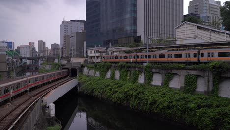 Marunouchi-Line-Train-And-Chuo-Line-At-Ochanomizu-Station-With-High-Rise-Buildings-In-Tokyo,-Japan