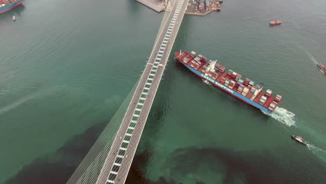 Cosco-mega-Container-Ship-crossing-Hong-Kong-Stonecutters-bridge,-heading-to-port