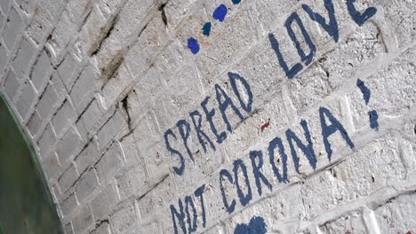 Corona-virus-support-message-quote-graffiti-painting-on-brickwork-wall-underground-dolly-right-slow