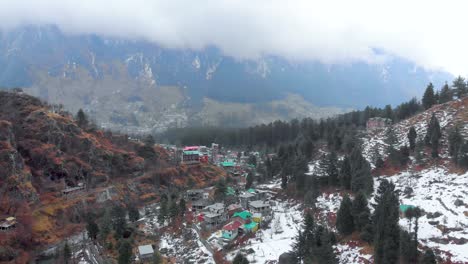 Aerial-Flying-Backward-shot-of-Old-Manali-Town-after-the-Snowfall-near-the-Manalsu-River-Front-in-Himachal-Pradesh-shot-with-a-drone-in-4k