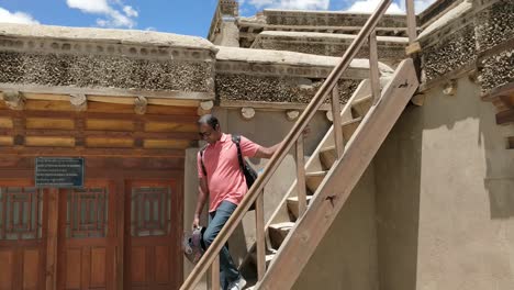 a-tourist-getting-down-from-the-stairs-of-leh-palace