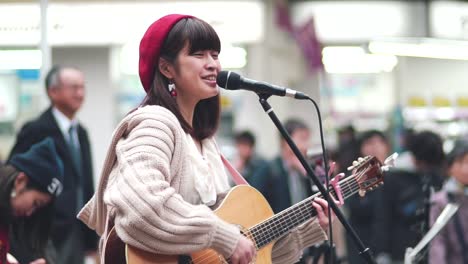 Young-Japanese-Girl-A-Guitarist-And-Singer-Songwriter-Busking-Happily-In-Kawaramachi-Street-In-Kyoto,-Japan