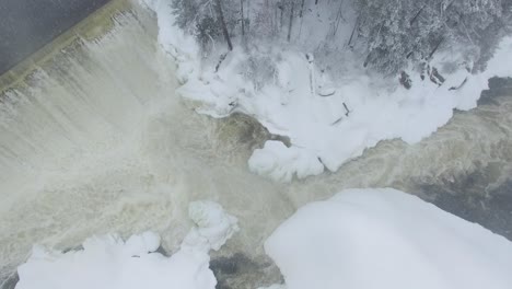 Bird's-eye-view-of-river-flowing-in-freezing-winter-filmed-by-drone-flying-down