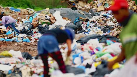 scavengers-recycling-rubbish-from-landfill-site,-trying-to-collect-something-valuable