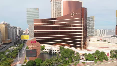 Rotating-and-rising-aerial-view-of-famous-Wynn-Casino-Hotel,-Macau