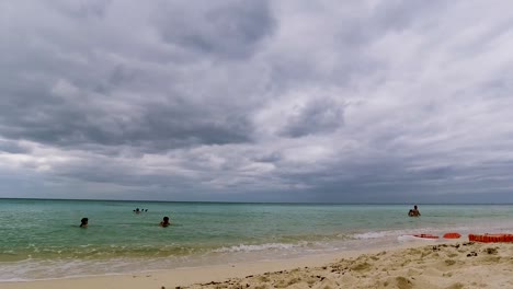 A-daytime-timelapse-of-tourists-playing-around-on-the-beach-in-Akumal-beach-resort,-Mexico