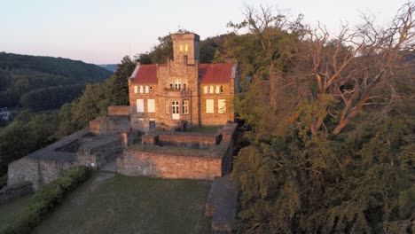 Isenburg-Restaurierte-Mittelalterliche-Burg-Im-Morgengrauen,-Luftdrohne-Enthüllen-Schuss
