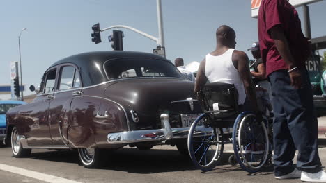 Klassische-Chevrolet-Styleline-Aus-Den-1950er-Jahren,-Schwarzer-Handicap-Mann-Im-Rollstuhl-Fährt-Auf-Der-Autoshow-Herum