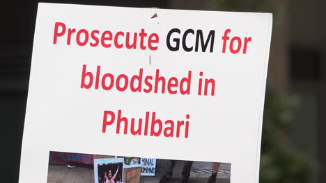 A-placard-says-“Prosecute-GCM-for-bloodshed-in-Phulbari”-on-a-protest-marking-the-14th-anniversary-of-three-killed-during-demonstrations-in-Phulbari,-Bangladesh