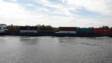 Niederländisches-Schiff,-Das-Mit-Fracht-In-Container-Beladen-Wird,-Die-Auf-Einem-Fluss-Segeln