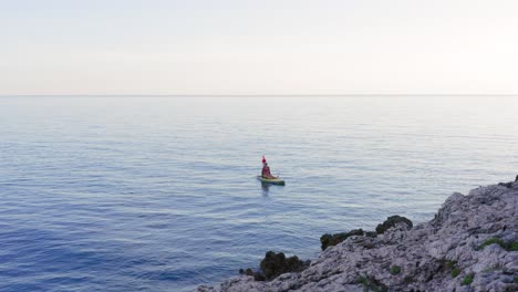Woman-sitting-on-a-paddle-surf-board-in-the-mediterranean-coast-of-Croatia