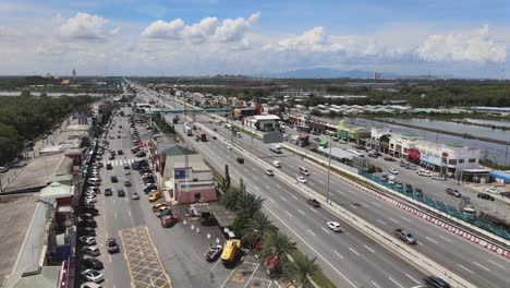 Static-Aerial-shot-of-a-Thai-Highway-with-moving-traffic-and-a-rest-stop-with-restaurants