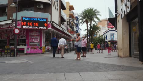 Locked-shot-of-a-pedestrian-street-in-Benidorm-with-Tourists-and-locals-wearing-protective-masks-during-coronavirus-pandemic
