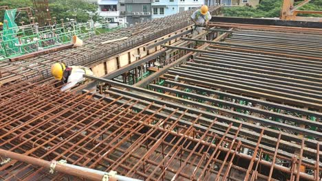 Construction-workers-fabricating-steel-reinforcement-bar---timber-formwork-at-the-construction-site
