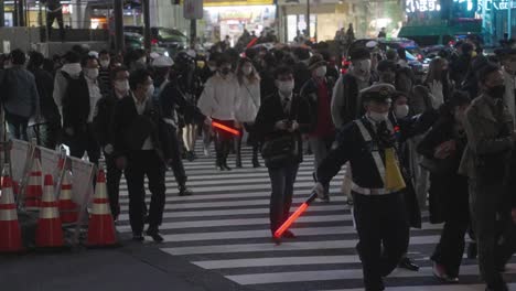 Policemen-In-Masks-Controlling-The-Crowd-At-Shibuya-Crossing-On-Halloween-Night-In-Tokyo,-Japan-During-Pandemic---slow-motion