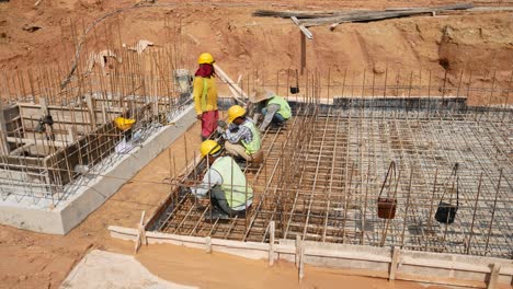 Construction-workers-installing---fabricating-timber-formworks-and-reinforcement-bar-at-the-construction-site