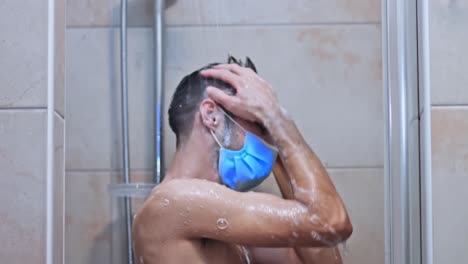 Young-Caucasian-guy-standing-in-the-shower-wearing-medical-mask