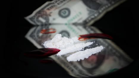 Ein-Haufen-Weißes-Kokainpulver-Mit-Blutfleck-Auf-Schwarzem-Glasdrehtisch-Gegen-Verschwommenen-Dollarschein