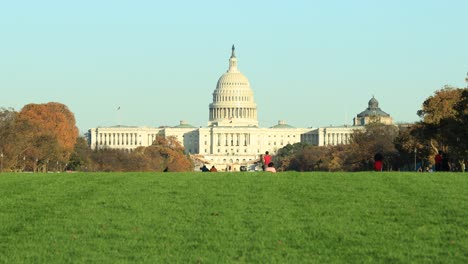 Front-view-of-US-Capitol-building-and-tourists-relaxing-on-lawn