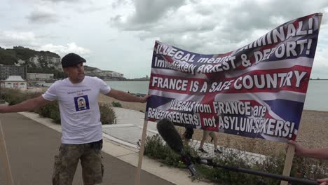 Manifestante-Sostiene-Pancarta-En-Protesta-Contra-La-Inmigración-Ilegal-En-Dover,-Kent,-05-09-20