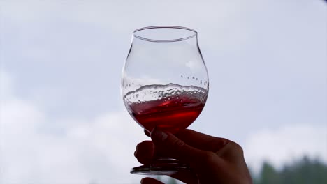 Glass-of-wine-swirling-slow-motion-with-the-sky-in-the-background