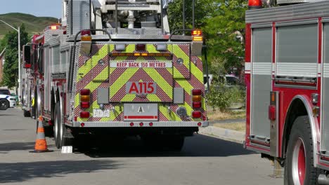 Firefighters-rolling-out-equipment-from-fire-engine-at-scene-of-fire-in-Mississauga,-Canada