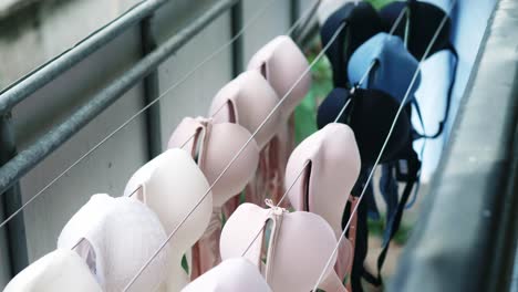Selective-focus-of-women's-various-colors-bras-that-are-being-dried-outdoors-from-weekly-washing
