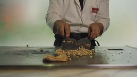 Chef-Teppanyaki-Cocinando-En-Una-Plancha-Caliente-En-Un-Restaurante-Asiático