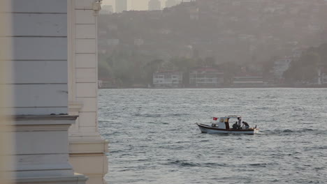 Turkish-Flagged-Motor-Boat-Sailing-on-Wavy-Marmara-Sea-of-Istanbul-Bosphorus-between-Continents-on-Sunset-Time