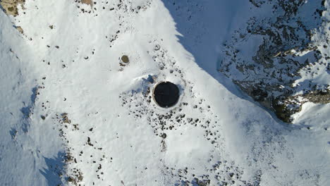 Luftbild-Eines-Brunnens-In-Den-Schneebedeckten-Bergen,-Sierra-De-Serella,-Alicante,-Spanien