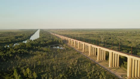 Dolly-In-Zarate-Brazo-Largo-Straßen--Und-Eisenbahnkomplex-Schrägseilbrücke-Zwischen-Grünen-Feldern-Und-Fluss-Zur-Goldenen-Stunde,-Entre-Rios,-Argentinien